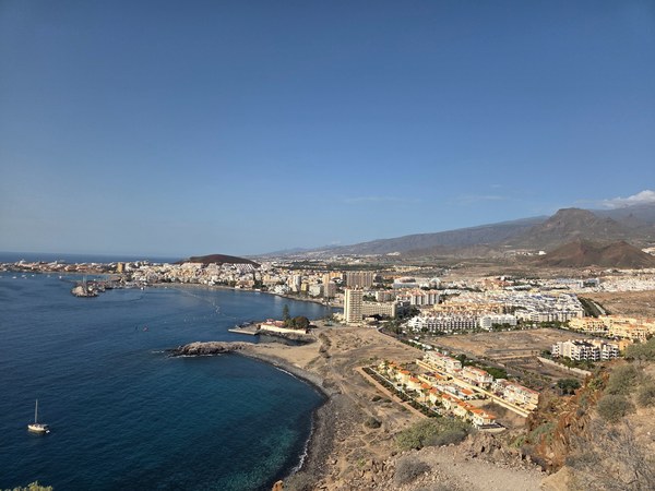 Vista panorámica de Los Cristianos desde un mirador elevado con la bahía, edificios y montañas del sur de Tenerife.