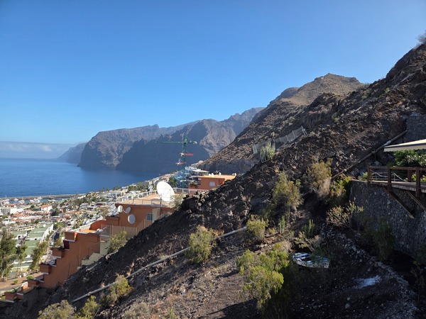 Mirador con vista a Los Gigantes, acantilados volcánicos, mar azul y ladera rocosa en Tenerife.