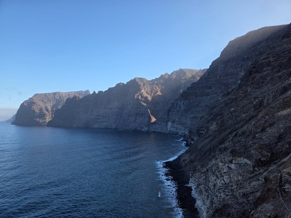 Acantilados de Los Gigantes cayendo sobre el océano en una escena de costa abrupta y sombría.